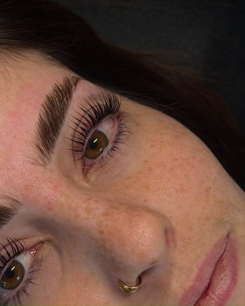 Nahaufnahme eines Auges mit aufgerichteten und getönten Wimpern nach einem Korean Lashlifting